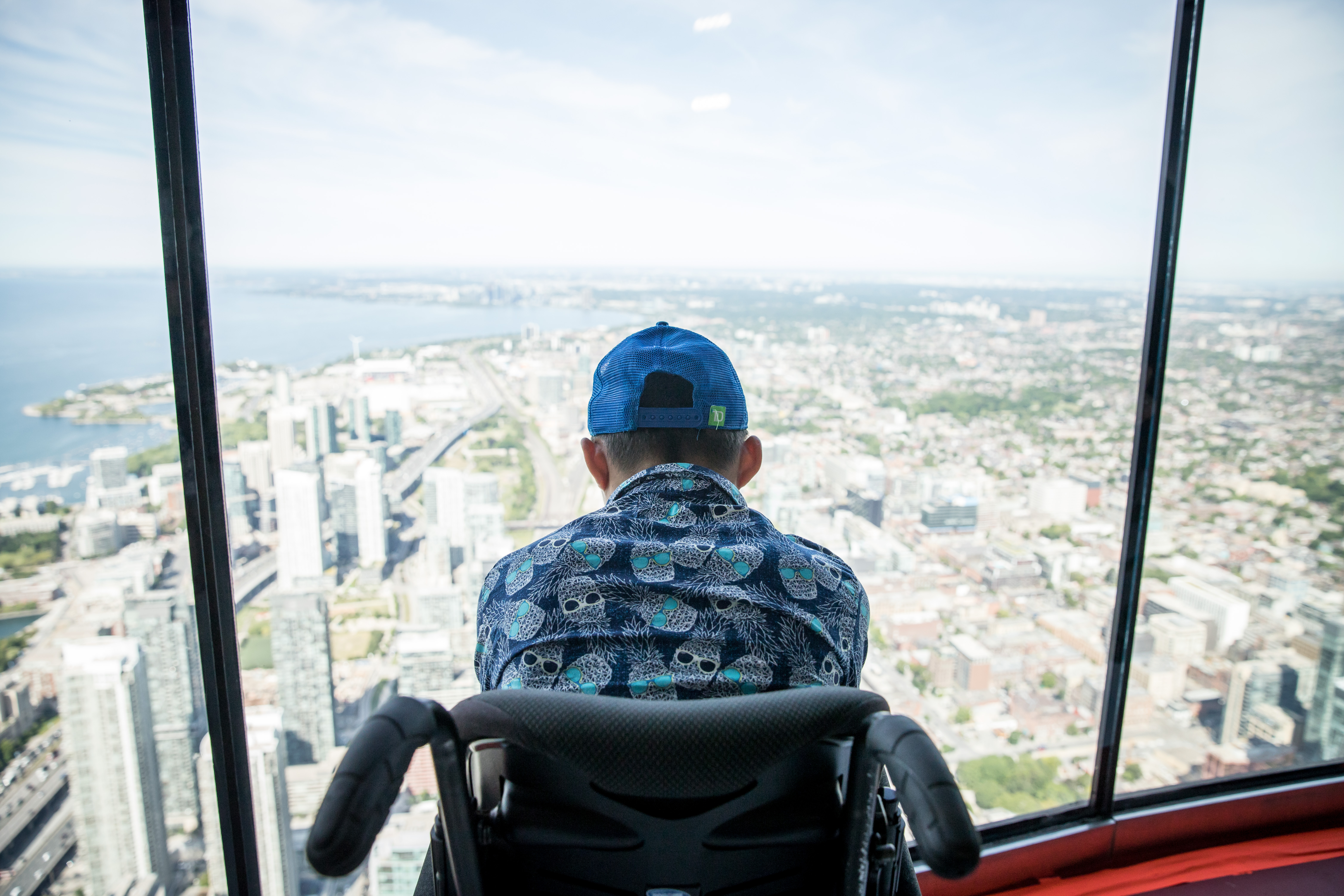 personne en fauteuil roulant regardant par la fenêtre à la Tour CN