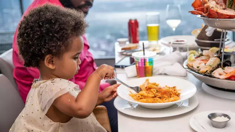 jeune enfant mangeant des pâtes au restaurant 360