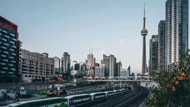 Tour du CN en arrière-plan et le Go Train et les voies ferrées au premier plan.