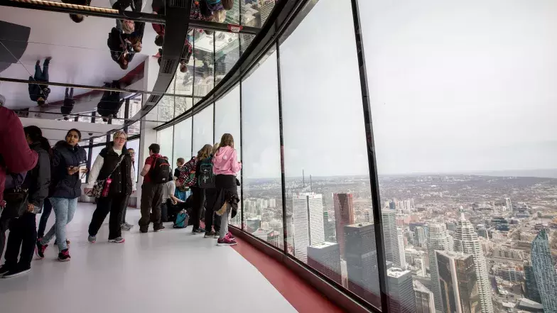 Un groupe de jeunes près de la fenêtre regardant la ville.