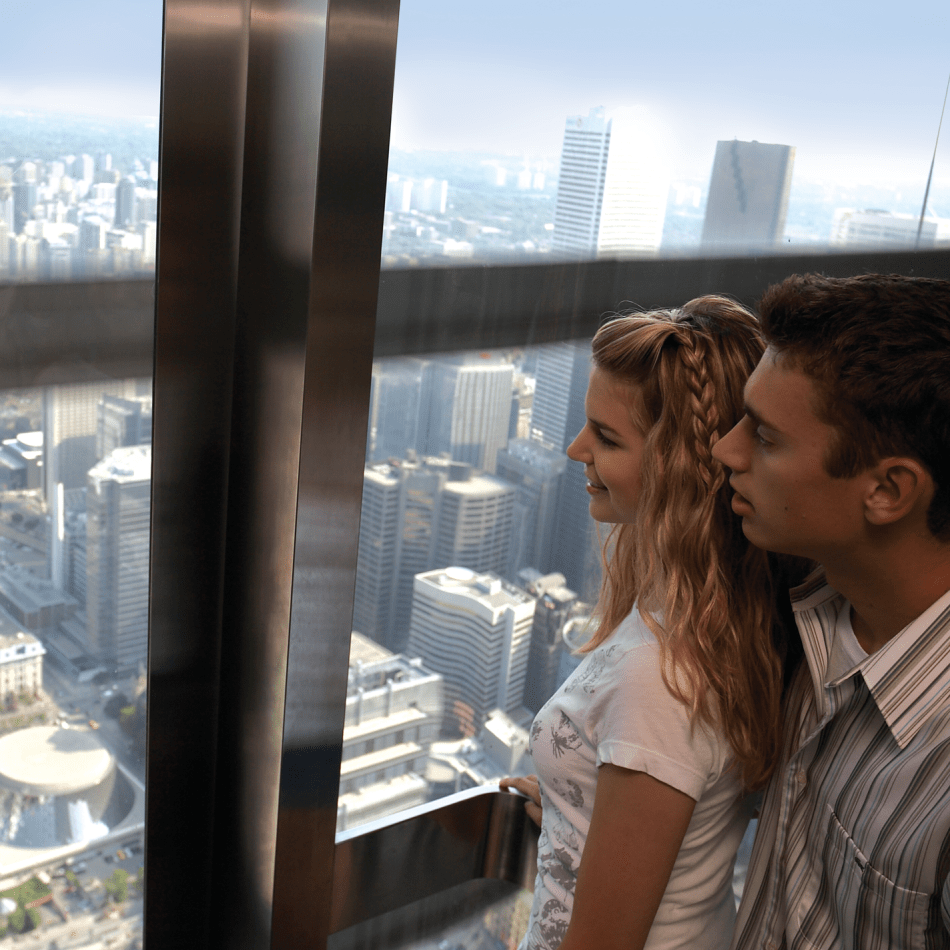 Deux personnes regardant par la fenêtre de l'ascenseur. La ville en arrière-plan.