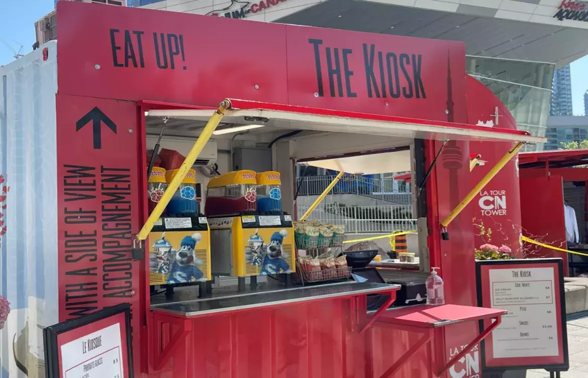 Un kiosque de restauration situé sur la Place de la Société Immobilière du Canada, où sont exposés divers produits tels que des barbotines et des croustilles.